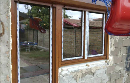Balkonska vrata i dvokrilni prozor u laminaciji ZLATNI HRAST sa spoljašnjom AL.roletnom.