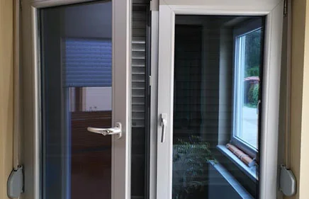 Dvokrilni PVC prozor sa fiksnom prečkom u sivoj laminaciji sa roletnom