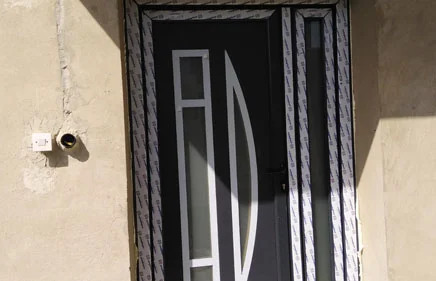 Dvokrilna ulazna vrata u ANTRACIT boji sa ukrasnim panelom AX-100 u glavnom krilu i peskarenim staklom u pomoćnom krilu.